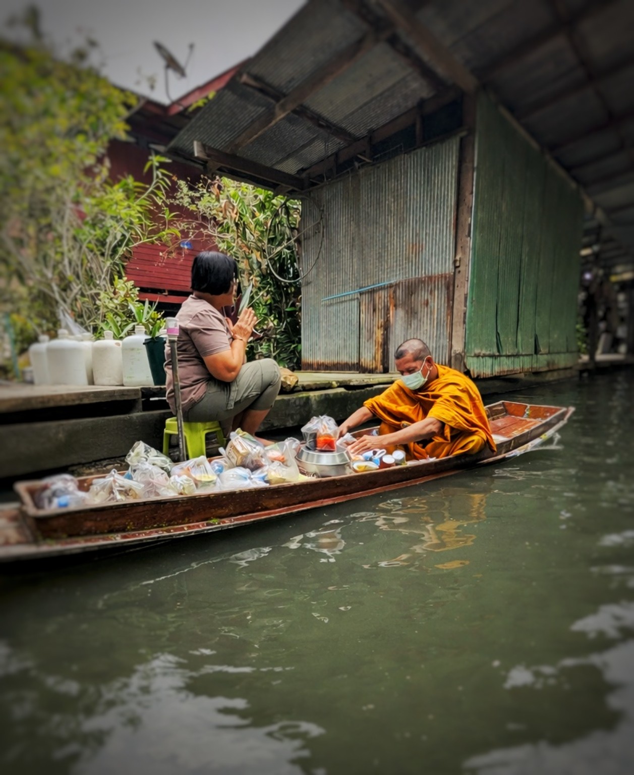 Lille båd og hverdagsliv langs en kanal i Thailand